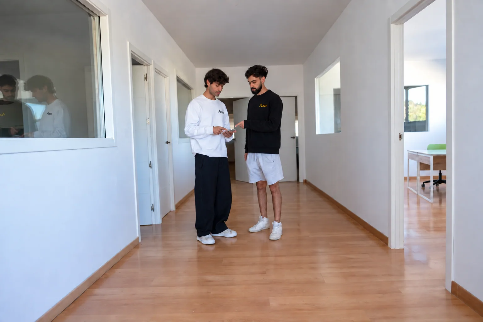 Dues persones de l’equip d’Ausa conversant al passadís