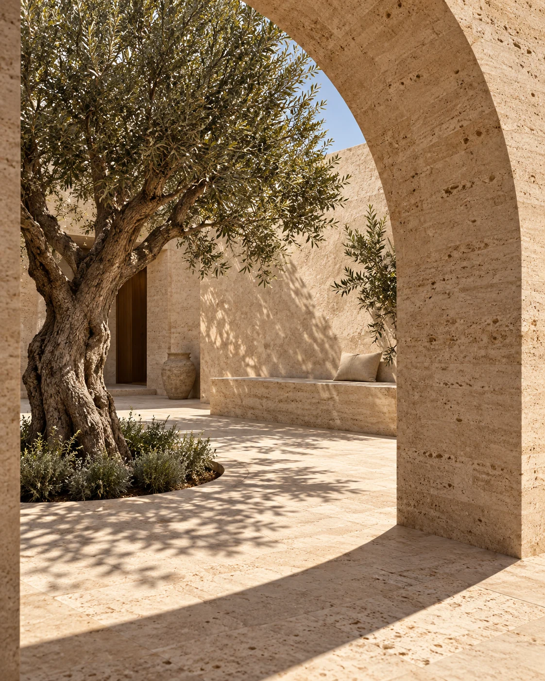 An olive tree and curved arch in Cala’s sheltered travertine courtyard